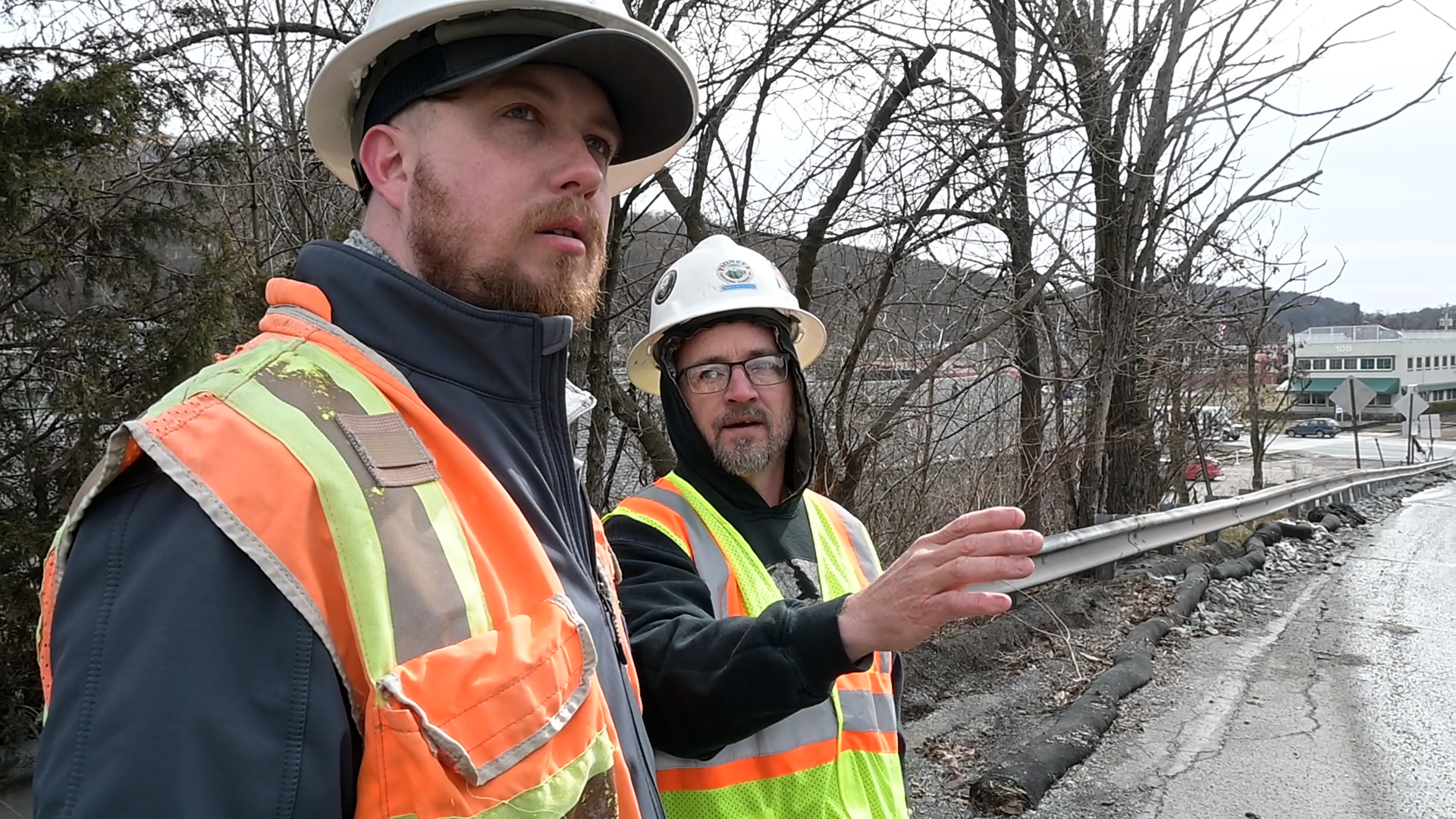 Two workers in hard hats and high-visibility vests review the storm line repair site in Honesdale, PA.